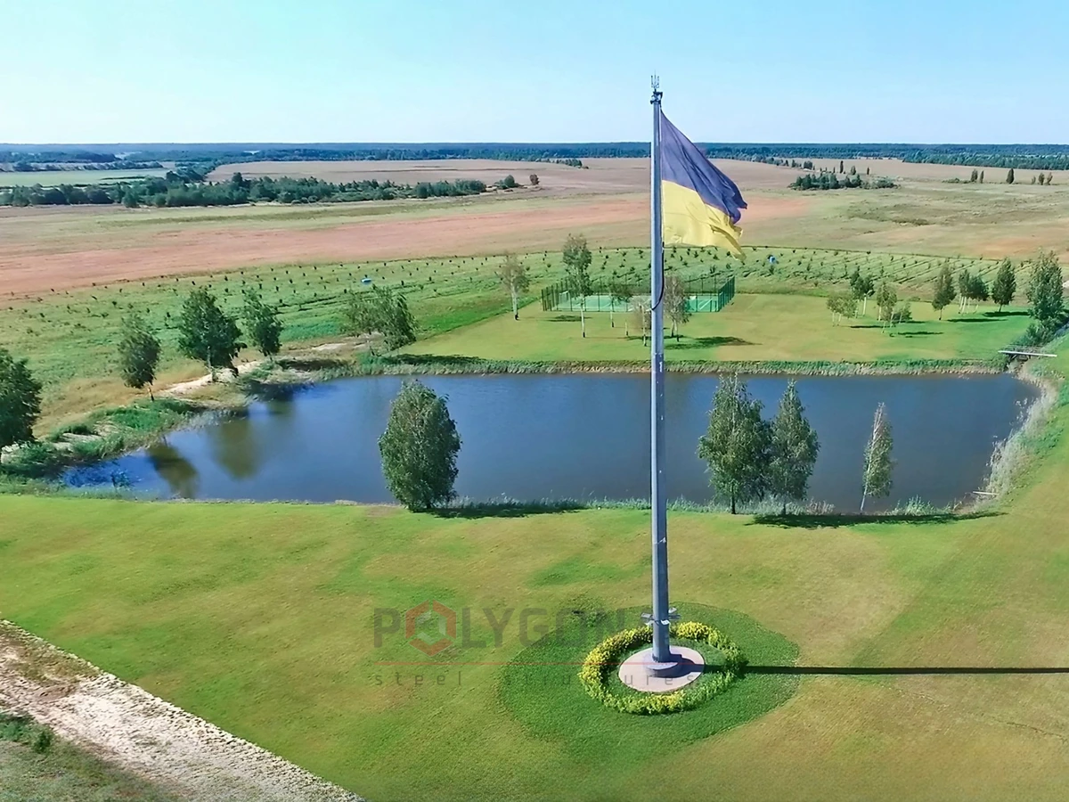 A flagpole from above: a pond and a field
