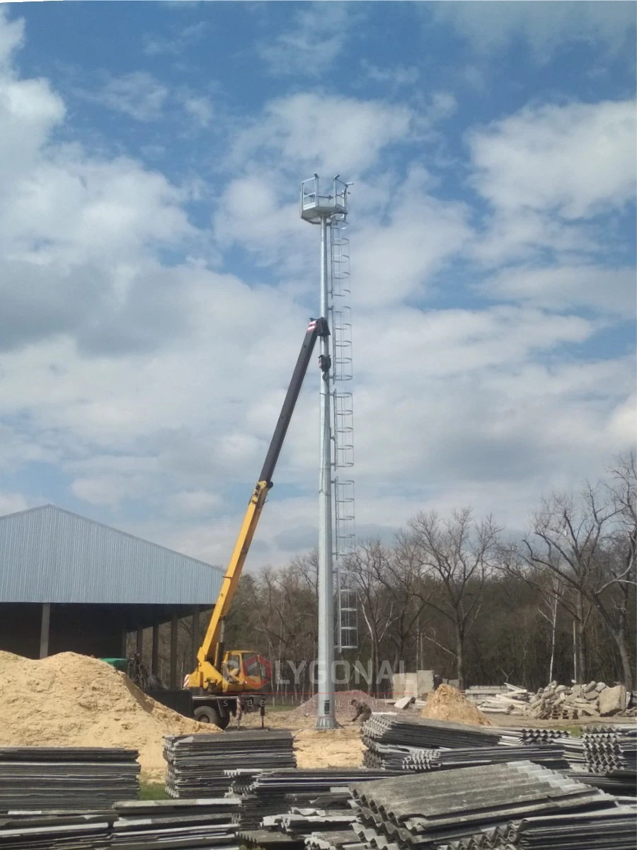 Lifting a floodlight mast with a mobile crane at an industrial site